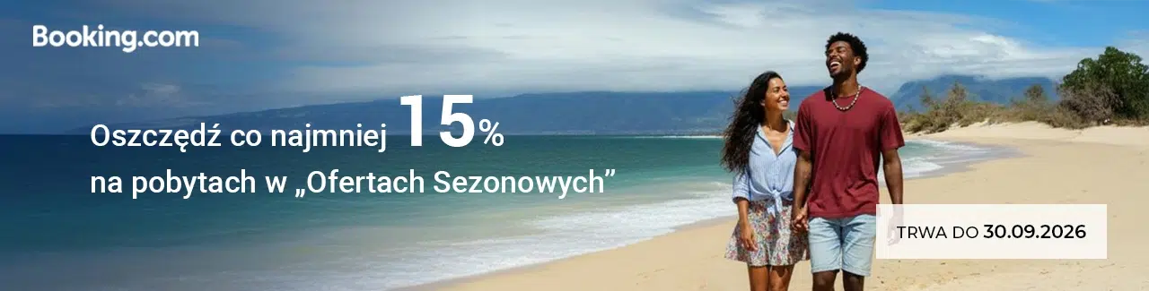Baner promocyjny Booking.com z informacją o oszczędności co najmniej 15% na pobytach w ofertach sezonowych, przedstawiający parę spacerującą po plaży oraz termin promocji do 30.09.2026.