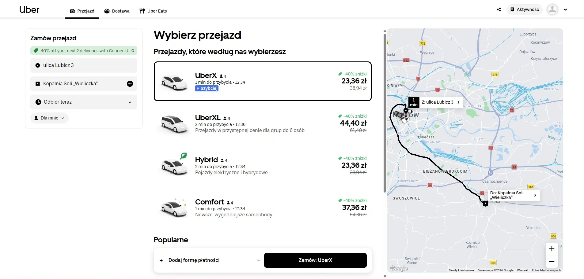 Panel wyboru przejazdu Uber w Krakowie z trasą z ulicy Lubicz 3 do Kopalni Soli ‘Wieliczka’, lista opcji UberX, UberXL, Hybrid i Comfort z cenami oraz mapa trasy po prawej stronie.